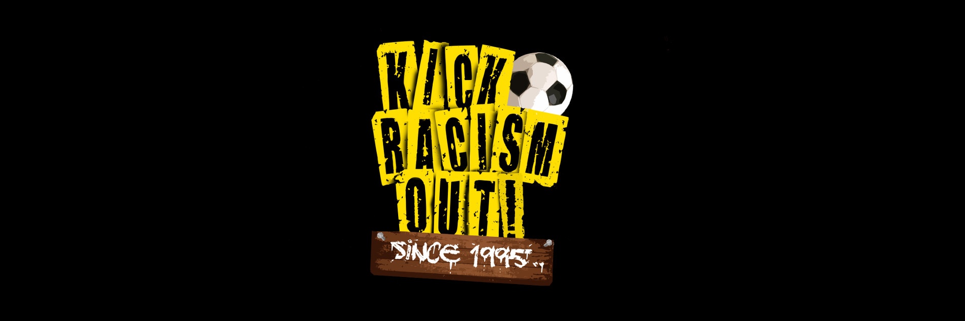 Gelbe-schwarzer "Kick Racism Out"-Schriftzug mit einem braun-weißen "Since 1995"-Schild in Holzoptik sowie einem schwarz-weißen Fußball garniert.