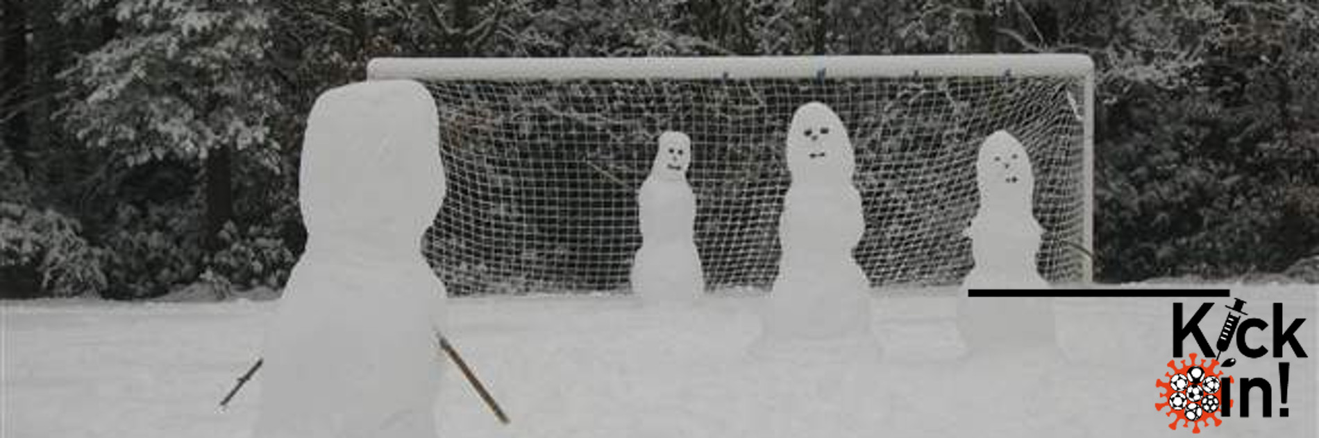 Vier Schneefiguren auf einem verschneiten Fußballfeld.