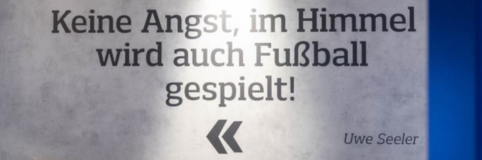 Wandbild mit einem „„Keine Angst, im Himmel wird auch Fußball gespielt!“-Zitat von Uwe Seeler.