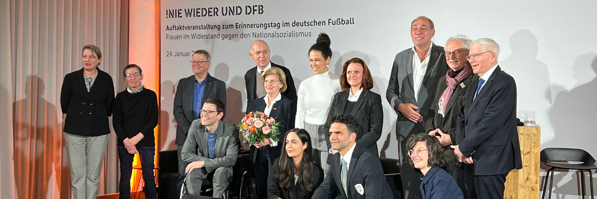 Gruppe von Menschen vor einem "Nie wieder & DFB"-Schriftzug.