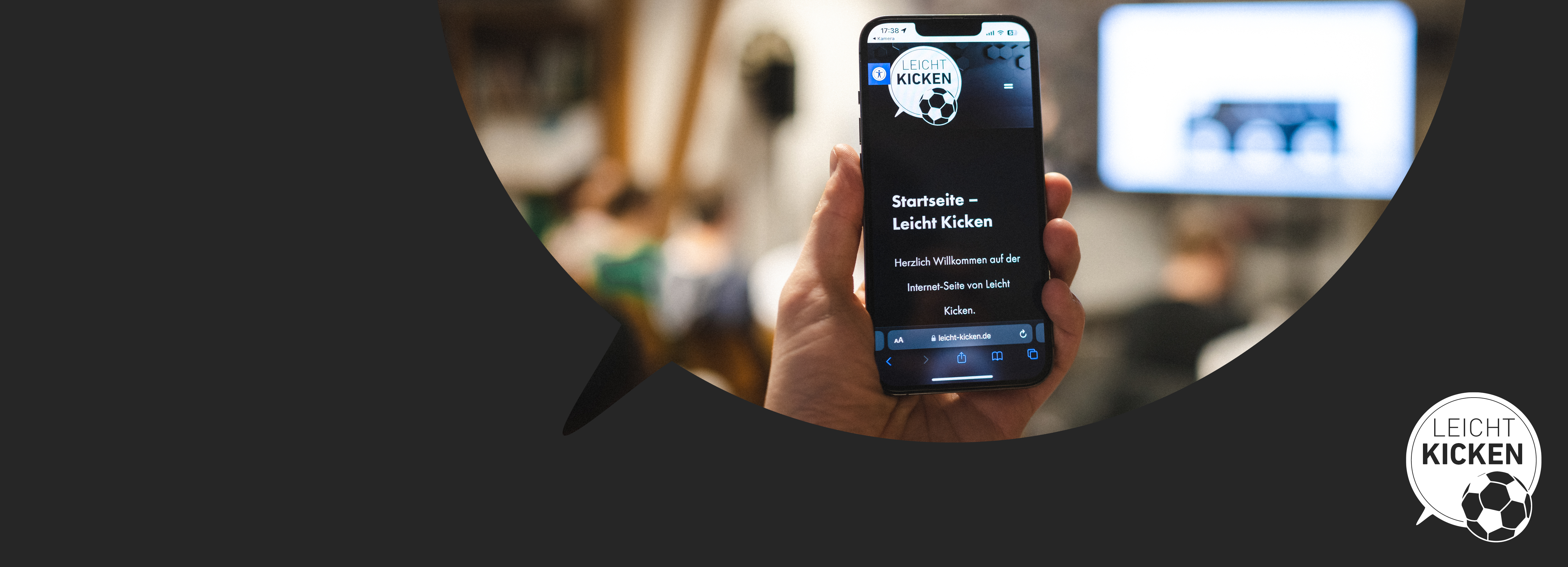 Eine Hand hält ein Smartphone hoch. Auf dem Telefon ist die Leicht Kicken-Webseite zu sehen.
