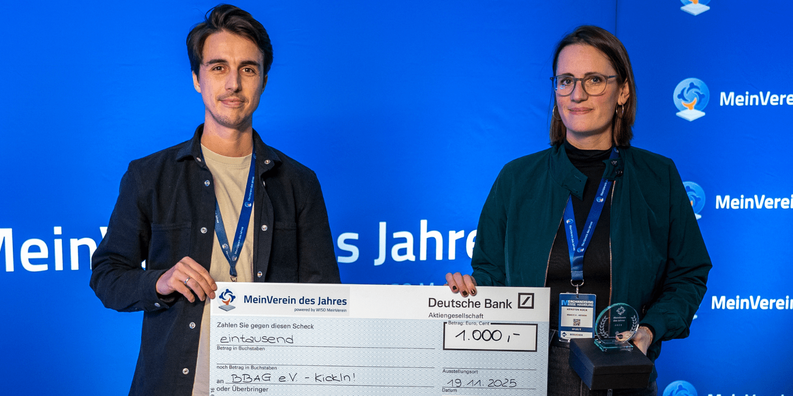 Carlo und Kerstin halten einen Scheck über 1000€ in der Hand