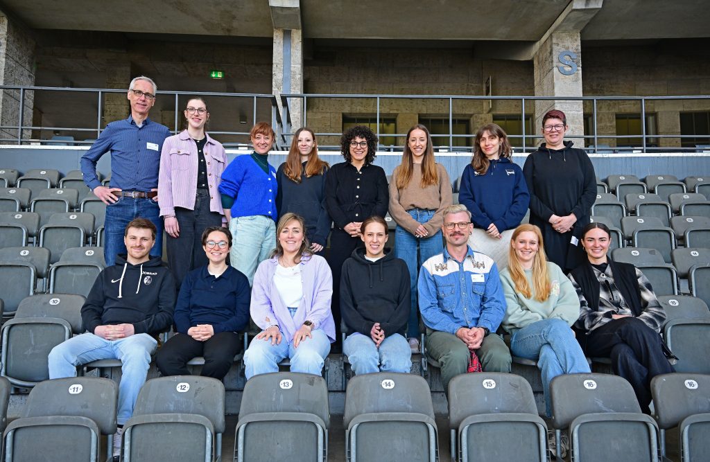 Eine Gruppe von Personen sitzt in einem Stadion