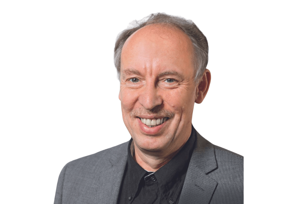 Michael lächelt in die Kamera. Er trägt ein Sakko mit Hemd. 